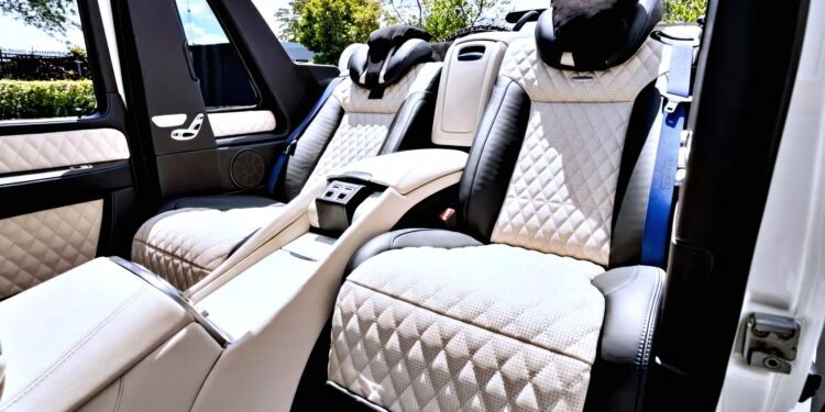 Interior of a luxury Mercedes-Maybach G650 for sale, featuring two large quilted leather seats with headrests and a central armrest console under bright daylight.