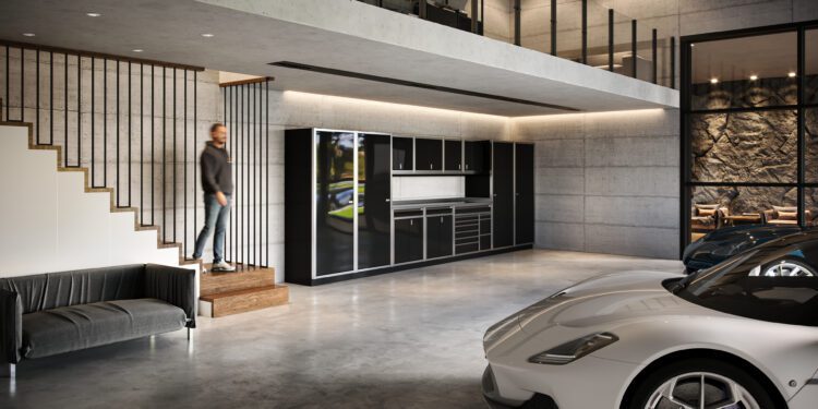 A man descends stairs into a modern garage with concrete walls, a black sofa, a kitchen area, and two parked sports cars—an impressive space that reflects refined living and luxury home accessories.