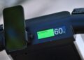 A close-up of an Olto electric scooter’s dashboard showing a charging status at 60%, with a smartphone mounted on the handlebar, ready to cruise down the bike lane.