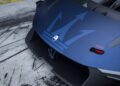 Close-up of a blue Maserati’s rear, showcasing the large trident logo, visible tow hook, and black aerodynamic features—likely from the MCXtrema—set on a concrete surface marked with tire tracks, hinting at action on Monza’s famed circuit.