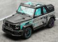 A custom two-door SUV with exposed carbon fiber body, teal and purple accents, street art-style graphics, turquoise interior, and off-road lights, parked indoors on a gray tile floor.