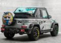 A customized G-Wagon by Mansory, inspired by Alec Monopoly, features vibrant graffiti-style artwork, a turquoise interior, and black wheels with yellow accents in a striking showroom display.