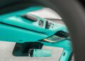 Close-up view of a turquoise G-Wagon dashboard featuring a push-to-start button, control switches, rearview mirror, and overhead lights.