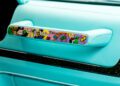 Close-up of a G-Wagon car door handle with turquoise leather and a colorful cartoon design featuring Alec Monopoly, Joker, money, and Mansory branding.