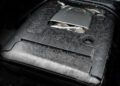 Close-up view of a G-Wagon engine bay customized by Mansory, featuring a carbon fiber engine cover with Mansory branding and exposed engine components.