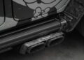 Close-up of a Mansory-branded quad exhaust system and custom side step on a G-Wagon, featuring Alec Monopoly-inspired decorative graphics on the body panel.