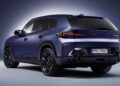 A matte blue 2026 XM Label BMW XM SUV is shown from the rear three-quarter view against a gradient background, highlighting its angular design and distinctive taillights.