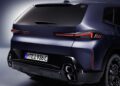 Rear view of a dark blue 2026 XM sports utility vehicle, showcasing taillights, rear badging, license plate, and quad exhaust outlets.