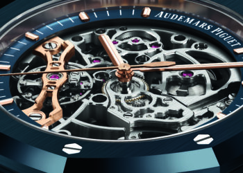 Close-up of an Audemars Piguet watch face showcasing horological highlights—visible intricate gears, rose gold details, and a blue outer ring with screws—making it a standout among the most expensive watches.