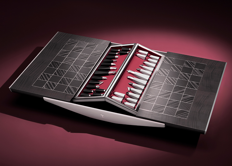 A modern, minimalist backgammon board with geometric patterns and sleek playing pieces, set on a dark surface with a burgundy background—an ideal addition for those seeking luxury home accessories that elevate refined living.