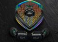 A pair of black Klipsch wireless earbuds with a jeweled, multi-colored triangular charging case on a dark textured surface—perfect for those seeking luxury accessories and a true style upgrade.