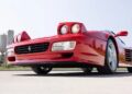 Close-up view of a rare Ferrari 512 TR Prototype with pop-up headlights raised, photographed from a low angle on a sunny day.