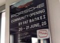 Poster advertising the Porsche Community Opening by FAT Mankei, featuring the 963 RSP, scheduled for June 20-21, 2025, displayed on a wall near a window.