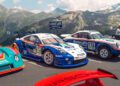 Three Porsche race cars, including a 963 RSP featuring the iconic FAT Mankei livery, are parked on a mountain road with scenic alpine peaks visible in the background.