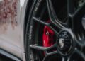 Close-up of a Luxembourg-Inspired 911 GT3 Touring wheel with black spokes, visible tire branding, and a red brake caliper—showcasing Porsche Sonderwunsch customization.