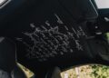 Black car interior with white handwritten text and a Nürburgring racetrack outline embroidered on the headliner, viewed from the passenger seat—Porsche Sonderwunsch touches hint at a Luxembourg Inspired 911 GT3 Touring.