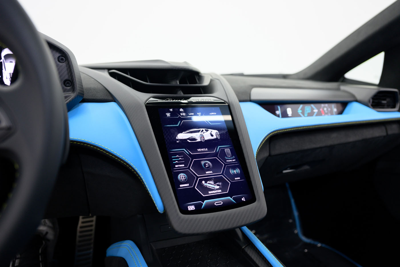Close-up view of a 2025 Mansory Lamborghini Revuelto’s futuristic dashboard, featuring a large central touchscreen displaying vehicle controls and blue interior accents in the U.S.