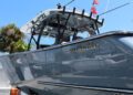 A close-up side view of a sleek, gray motorboat with the name "Valhalla" on the hull, docked outdoors under a clear blue sky—perfect for Florida boaters seeking style and durability with marine protection film.
