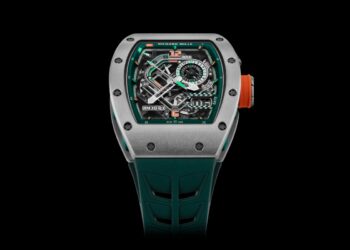 A silver Richard Mille RM 30-01 LMC watch with a skeleton dial, orange crown, and teal strap, displaying intricate mechanics and chronograph features against a black background—a true Le Mans Classic edition.