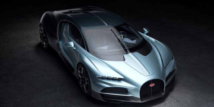 A silver Bugatti Tourbillon hypercar parked on a dark surface, viewed from above at an angle, showcasing its aerodynamic design and prominent front grille.