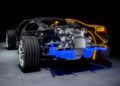 Cutaway view of a Bugatti sports car revealing the rear engine, suspension components, and blue-highlighted exhaust system, with neon lines outlining the car’s exterior shape in a striking tourbillon-inspired design.