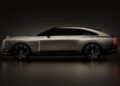 Side view of a sleek, matte gray Bentley concept EV with black wheels, sharp lines, and illuminated accents, set against a dark background.