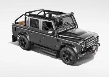 A matte black, four-door off-road vehicle with an open roof frame, rugged tires, and visible interior seating—a unique creation—stands out against a plain white background.