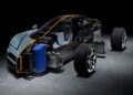 A partially transparent Bugatti sports car shows internal components, including seats, battery, and frame; the front and rear wheels are detached and positioned next to the car in a unique packaging display.