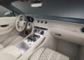 The interior of a Bentley showcases cream-colored leather seats, a polished center console with controls, and a digital dashboard, enhanced by exclusive Mulliner Interior Options.