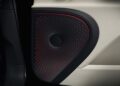 Close-up of a car door panel featuring a Bang & Olufsen speaker with a black and red perforated circular pattern, showcasing the luxurious Mulliner Interior—a highlight among Bentley's new options.