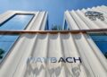 Modern Maybach building facade in Seoul with large glass windows, cream-colored panels, and a metallic "MAYBACH" sign; Maybach logo near the roof highlights this elegant Brand Center.