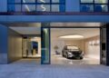 A Maybach car is displayed inside the sleek Maybach Brand Center in Seoul, featuring glass walls and minimalist decor.