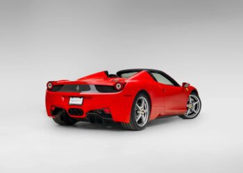 A red Ferrari 458 convertible sports car is shown from the rear three-quarter view against a plain, light gray background—an iconic example for those seeking the best Ferrari among cars for sale.