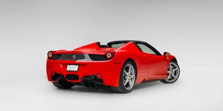 A red Ferrari 458 convertible sports car is shown from the rear three-quarter view against a plain, light gray background—an iconic example for those seeking the best Ferrari among cars for sale.