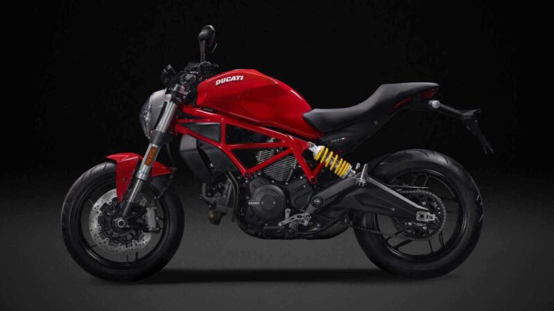 A red Ducati motorcycle is shown in profile against a black background, highlighting its frame, suspension, and engine details as a limited edition sculpture that blends artistry with cutting-edge engineering.
