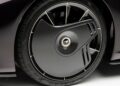 Close-up of a car wheel featuring a black aerodynamic carbon fiber cover with a central logo and low-profile Pirelli tire, found on this ultra-low mile McLaren Speedtail with $250k in MSO options heading to auction.