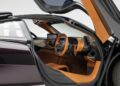 Open gullwing door reveals the tan and black leather interior of this ultra-low mile McLaren Speedtail with $250k in MSO options, showcasing the steering wheel, dashboard, and digital display as it heads to auction.
