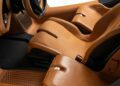 Tan leather bucket seats and black interior details in this ultra-low mile McLaren Speedtail, featuring $250k in MSO options, with a close-up view of the steering wheel and front cabin area.