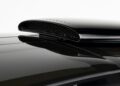 Close-up view of a glossy black car roof scoop with a honeycomb mesh insert, reminiscent of the ultra-low mile McLaren Speedtail with $250k in MSO options that's heading to auction, set against a plain white background.