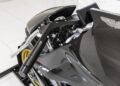 Close-up of a motorcycle's carbon fiber body and handlebar, featuring the Brough Superior emblem and glossy finish—this 2022 Aston Martin AMB 001 is a highlight of Sotheby's Motorsport.