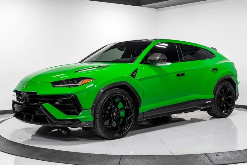 A bright green Lamborghini Urus SUV, an exotic car for sale, is parked in a well-lit showroom with white walls and a circular platform.