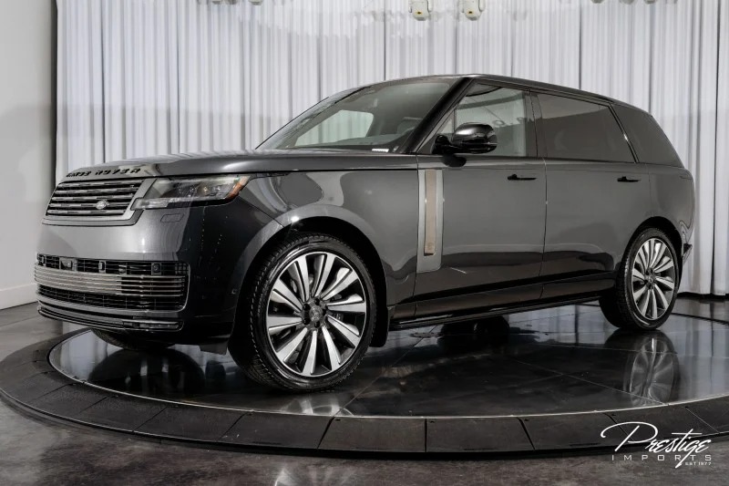 A black 2023 Land Rover Range Rover, one of the best Range Rovers, is displayed indoors on a rotating platform with white curtains in the background, highlighting its appeal as a luxury SUV.