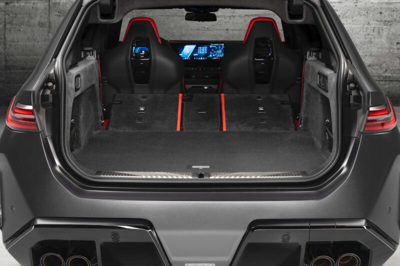 Open trunk view of a modern SUV with rear seats folded flat, revealing a spacious cargo area—reminiscent of the versatility seen in the Review: 2025 BMW M5 Touring Weighs In As A Great Allrounder—with digital displays visible through the front seats.