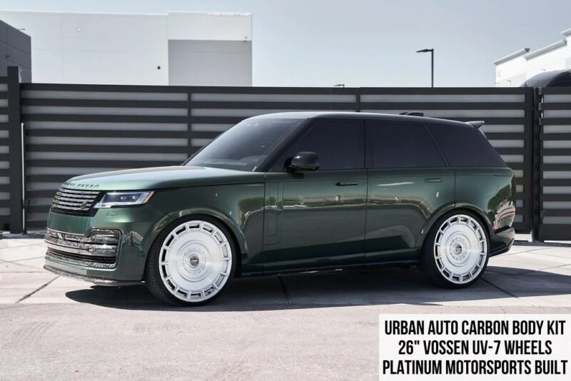 A luxury SUV, this dark green Range Rover features an Urban Auto carbon body kit and striking 26" Vossen UV-7 wheels, parked elegantly in front of a modern fence—showcasing why it ranks among the best Range Rovers.