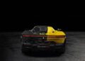 Rear view of a Tailor Made Daytona SP3 Ferrari, with the left half painted black and the right half yellow, displayed against a dark background. This unique model was featured at a Charity Auction.