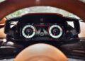 Digital car dashboard display in the 2026 Aston Martin Vanquish, featuring a speedometer, V12 tachometer, and drive mode indicator, all viewed from the driver's perspective.