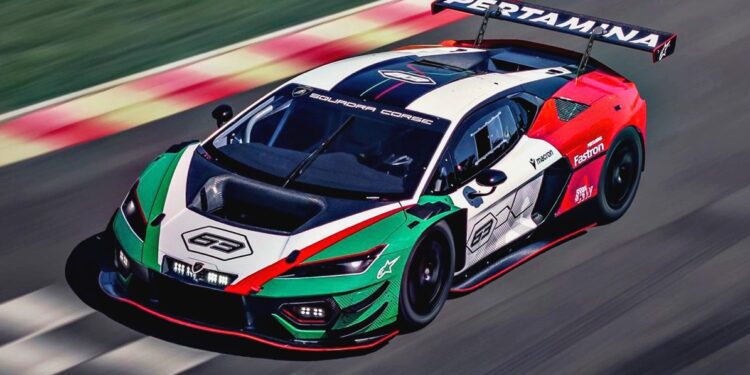 A Lamborghini race car with a green, white, and red livery speeds on a race track. The car features sponsor logos and a large rear wing.