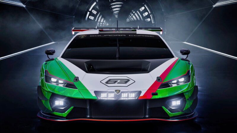 Front view of a green, white, and red Lamborghini race car with the number 63 on the hood, positioned in a futuristic, tunnel-like setting.