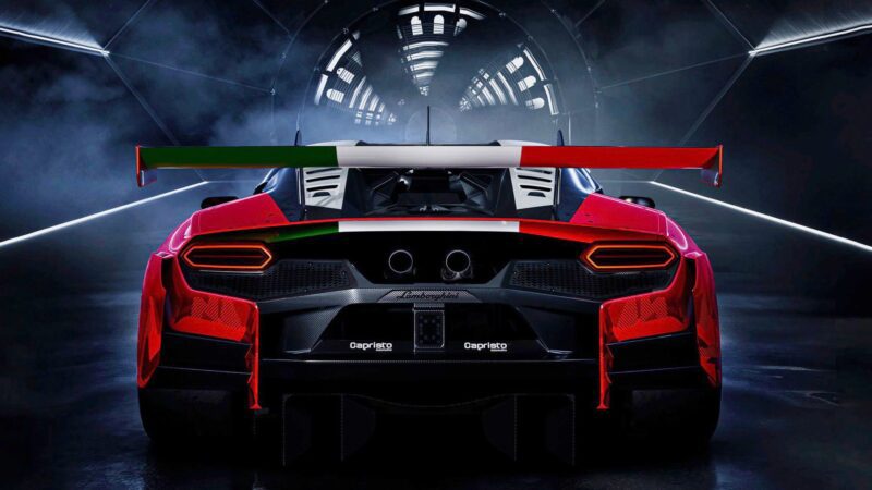 A red Lamborghini race car viewed from the rear, featuring a large rear wing with the Italian flag colors, inside a dark, futuristic tunnel.