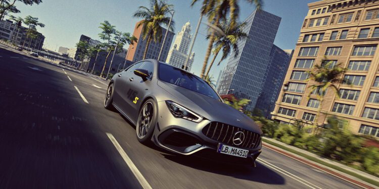 A matte grey Mercedes-Benz sports car drives down a palm-lined city street with modern buildings in the background under a clear sky.